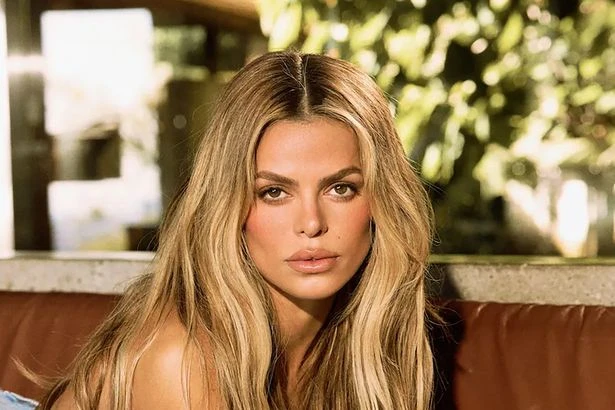 Baywatch star Brooks Nader goes completely topless while arching back on leather couch