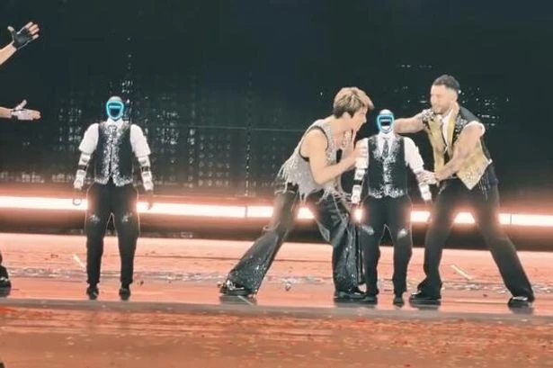 Glitching robot dancer falls over and hits popstar during concert malfunction