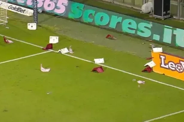 Italian football match abandoned as fans throw chairs and flares onto the pitch