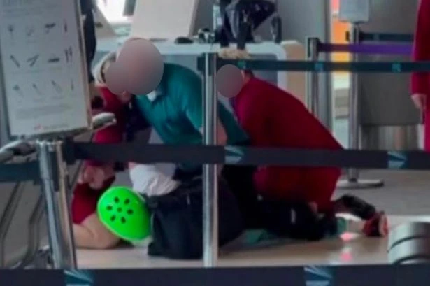 Airport chaos as Virgin cabin crew tackle man wearing bright green helmet to ground