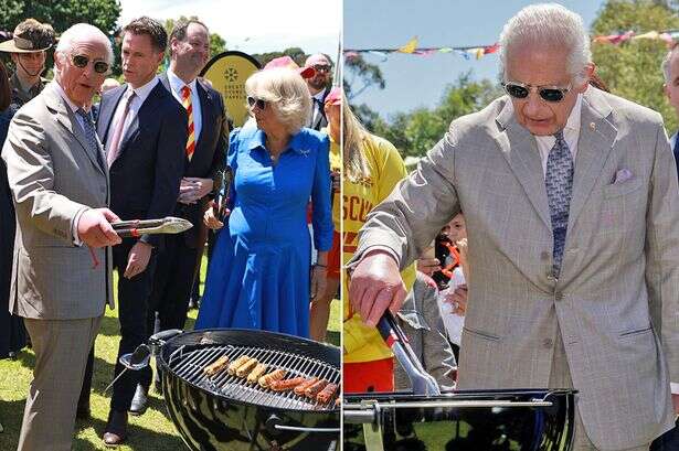 King Charles avoids accidentally grilling his fingers as he cooks sausages