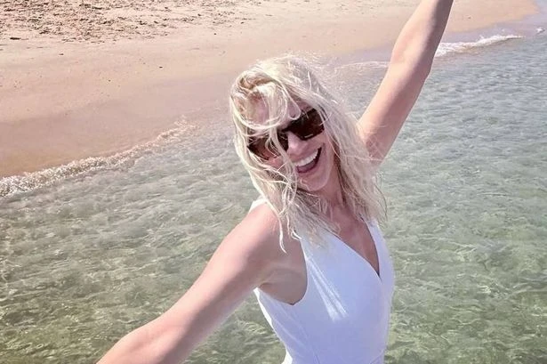 Holly Willoughby beams as she soaks up the sun in plunging white swimsuit