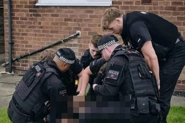 Moment 'man with brick' is bundled by cops after falling from window in school incident