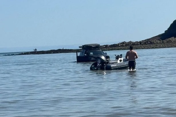 Baffled beachgoers say 'how did it get there' as car is seen submerged in water
