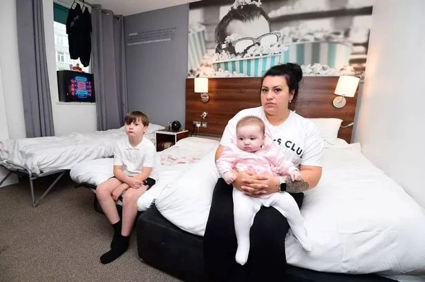 Single mum living in cramped hotel room with two kids forced to push beds together