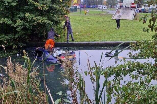 BMW submerged in West Bromwich canal as recovery truck arrives and man seen with rope