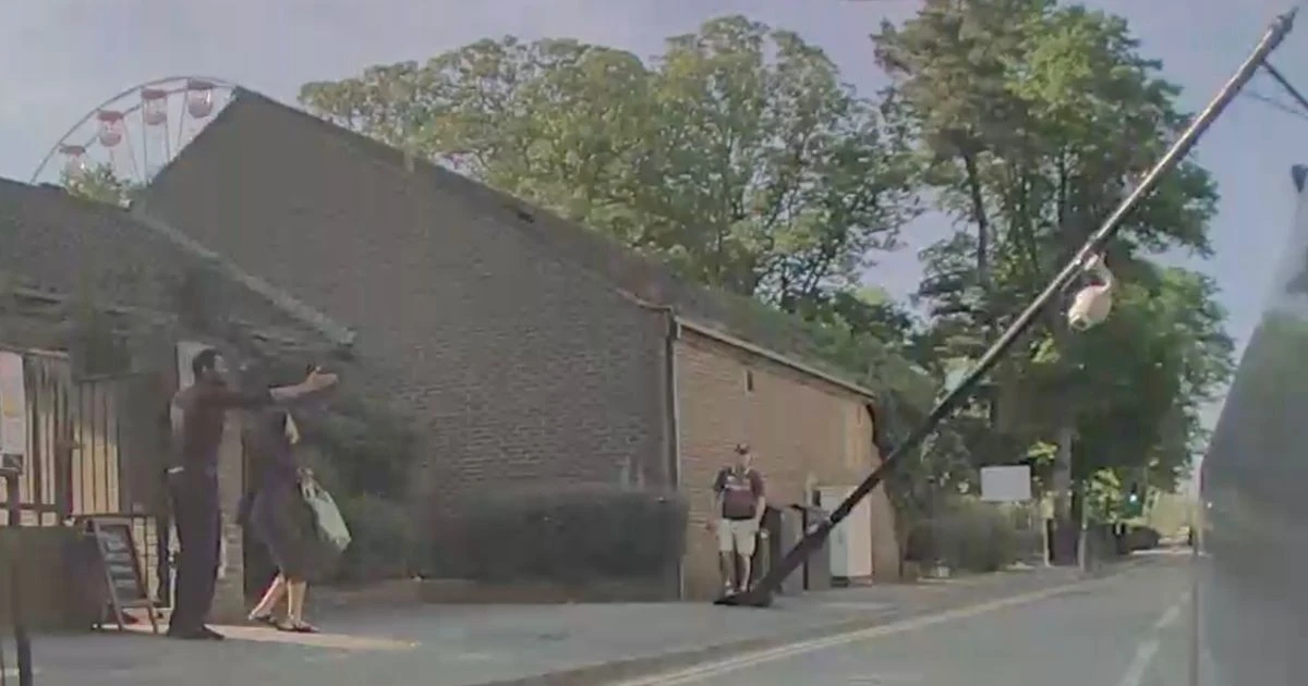 Lamppost crashes down across busy road narrowly missing astonished Tesla driverCCTV footage