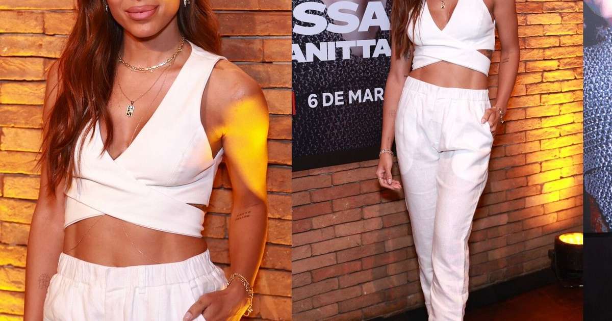 Anitta deixa abdômen sarado em evidência ao eleger conjunto total white para lançar novo documentário. Fotos do look!