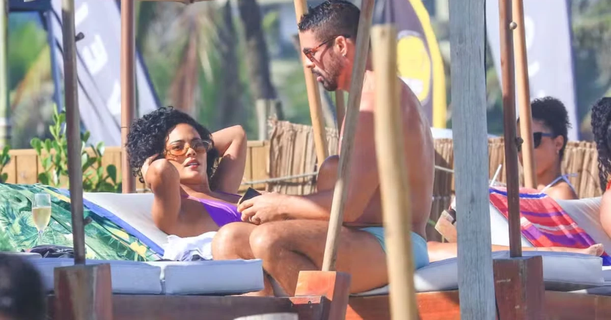 Paz selada? Cauã e Bella surgem juntos na praia gravando 'Vale Tudo' após polêmica nos bastidores